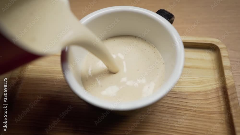 Barista makes coffee and pours a thick and fresh beverage into a mug. Hands and mug with coffee close-up Barista makes coffee and pours a thick and fresh beverage into a mug. Hands and mug with coffee close-up