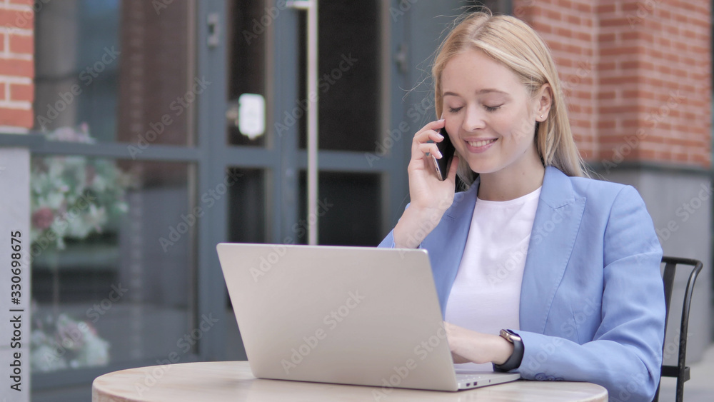 Young Businesswoman Talking on Phone, Sitting Outdoor Young Businesswoman Talking on Phone, Sitting Outdoor