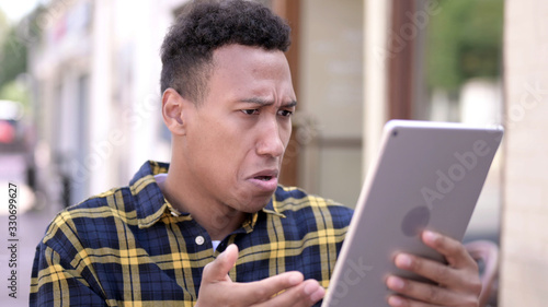 The Young African Man Reacting to Loss on Tablet, Outdoor