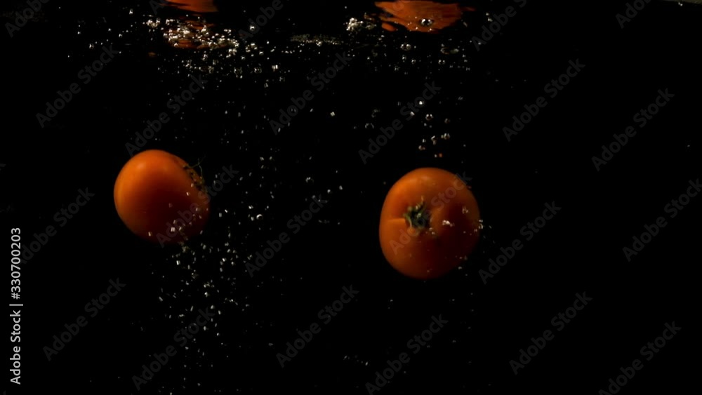 Two Whole Tomatoes Fell Into The Water And Stay Afloat. -medium shot Two Whole Tomatoes Fell Into The Water And Stay Afloat. -medium shot