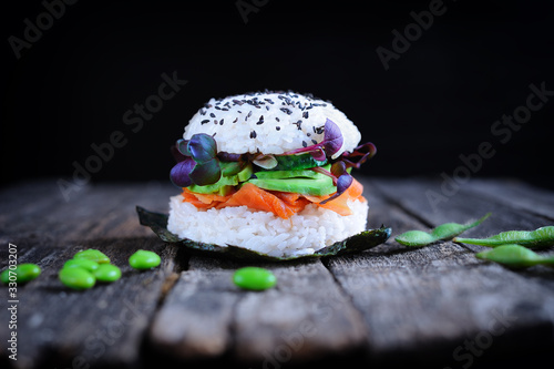Vegan sushi burger with carrot lox, avocado, cucumber, daikon sprouts and Japanese rice
