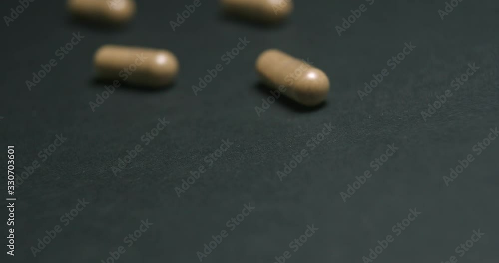 Pills medicine falling on black background close-up slow motion, studio shot in 4K prores HQ Pills medicine falling on black background close-up slow motion, studio shot in 4K prores HQ