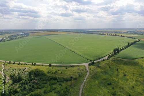  beautiful green field with shadows from moving clouds - Aerial Flight  photo