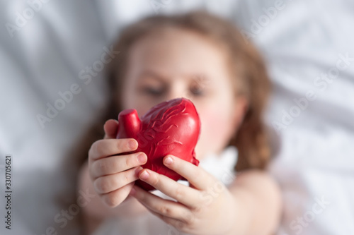 Little girl holding heart in her hands