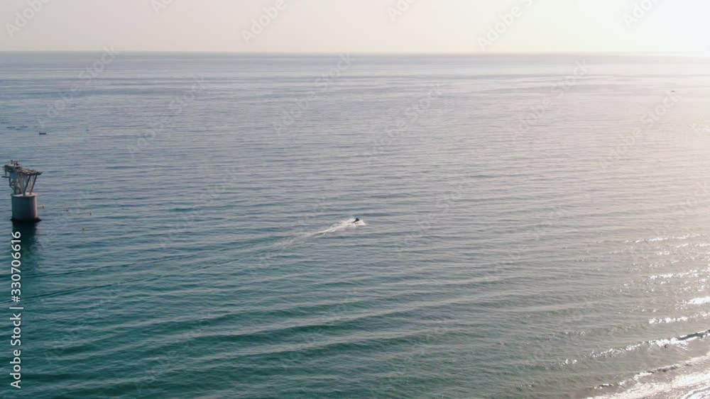 Aerial tracking shot of jet ski alongside coast of sunny Marbella Aerial tracking shot of jet ski alongside coast of sunny Marbella