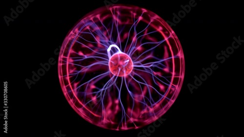 Plasma ball gives out small lightning. Experiments with electricity in the dark. photo