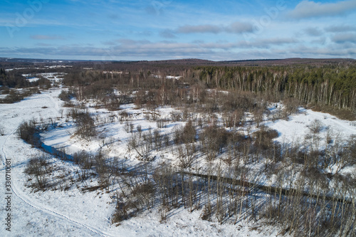 Beautiful Sunny landscape with forest and snow. Aerial photography from a drone