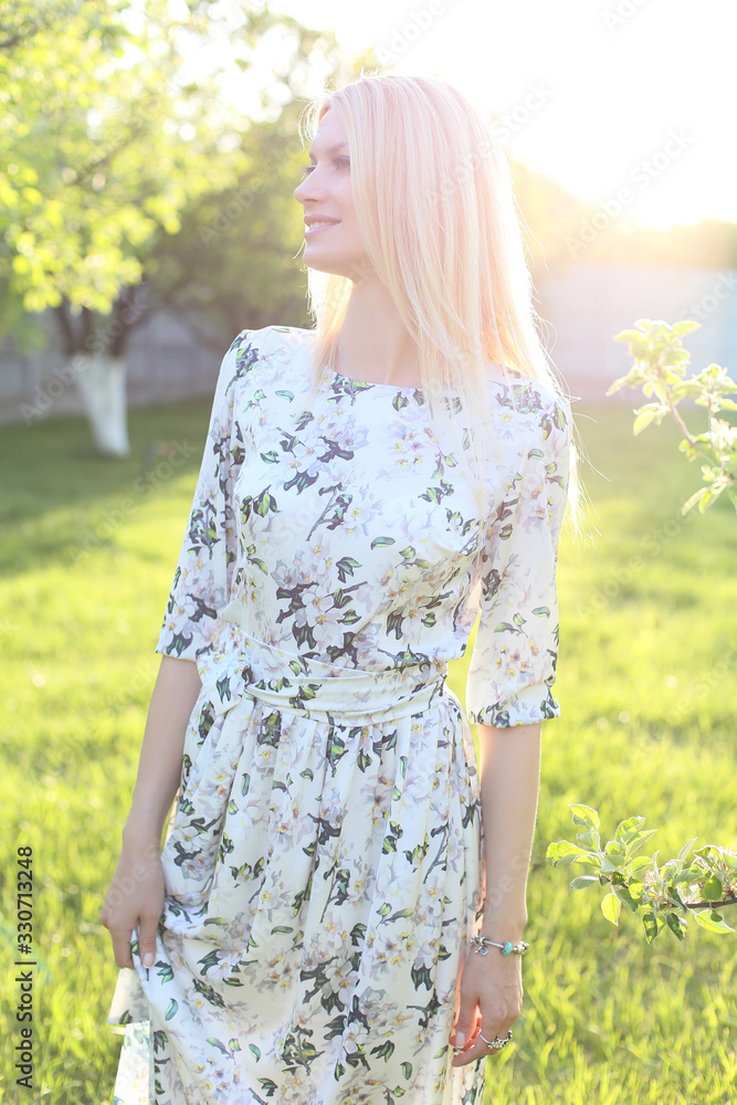 vertical portrait of a beautiful smiling blonde in a green garden vertical portrait of a beautiful smiling blonde in a green garden