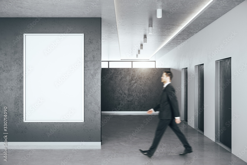 Businessman walking in minimalistic hall interior with blank banner on wall. Businessman walking in minimalistic hall interior with blank banner on wall.
