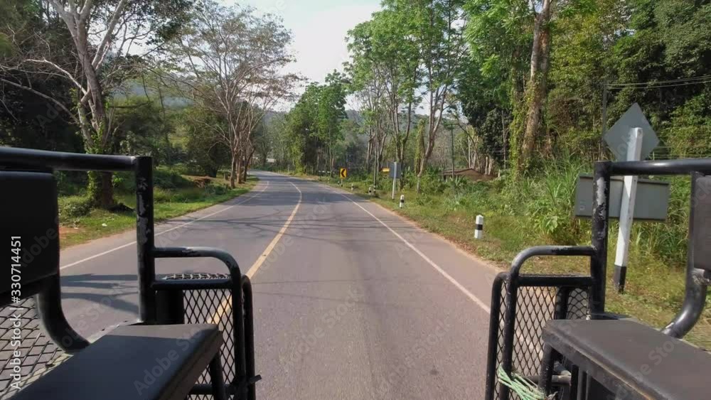 View of asphalt road in Khao Sok seen from back of a truck. View of asphalt road in Khao Sok seen from back of a truck.