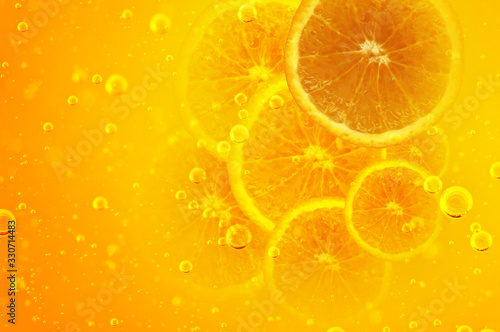 Orange juice. Halved orange in bubbling yellow liquid.