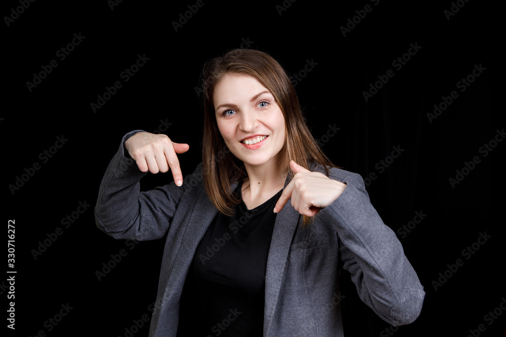 A cute young woman pointing down with two her fingers A cute young woman pointing down with two her fingers
