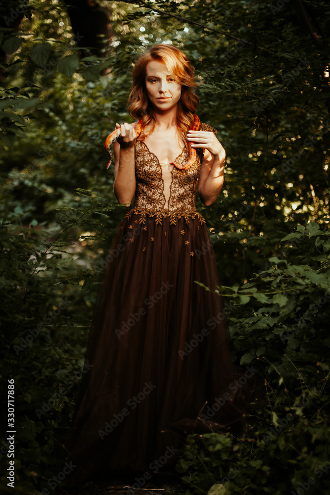 Beautiful redhead woman with orange snake