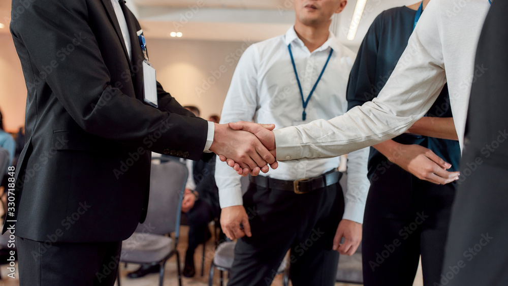 Because business matters. Cropped shot of diverse businesspeople having conversation standing together at meeting, men colleagues shaking hands at training conference. Because business matters. Cropped shot of diverse businesspeople having conversation standing together at meeting, men colleagues shaking hands at training conference.