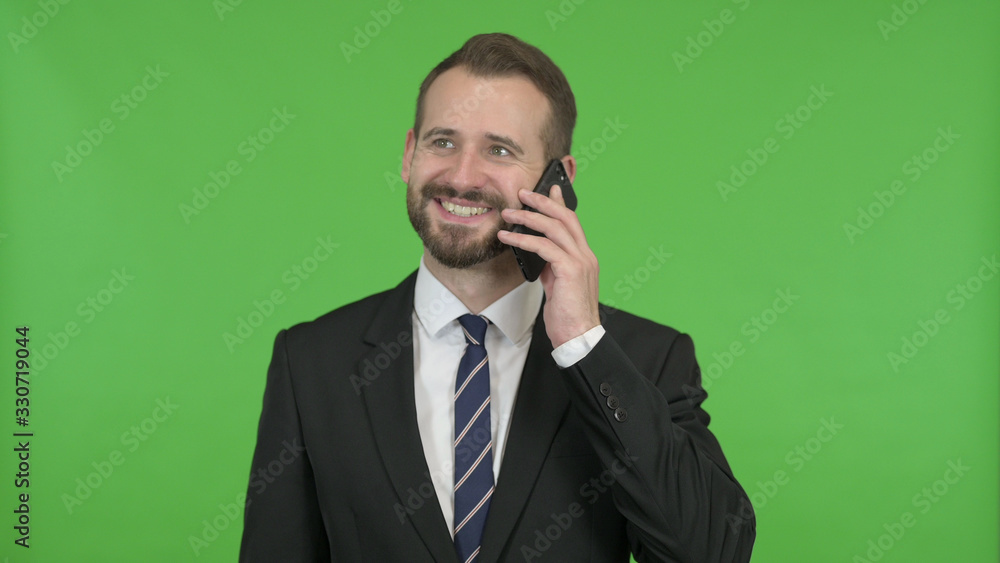 The Young Businessman Talking on his Cellphone against Chroma Key The Young Businessman Talking on his Cellphone against Chroma Key