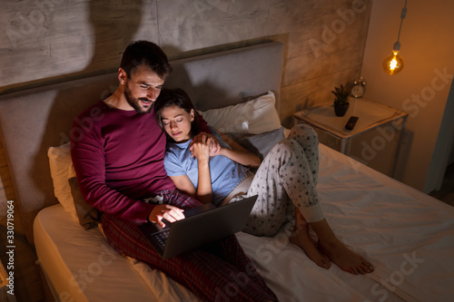 Couple relaxing in bed at night