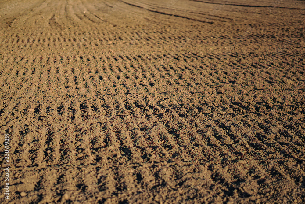 Plowed endless farm field. The fertile land of the agricultural sector. Sowing on black soil in the garden. Industrial stock theme Plowed endless farm field. The fertile land of the agricultural sector. Sowing on black soil in the garden. Industrial stock theme