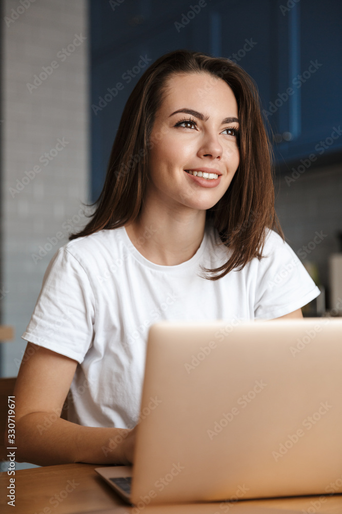 Happy woman indoors at home using laptop computer. Happy woman indoors at home using laptop computer.
