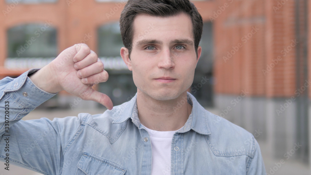 Thumbs Down by Young Man Standing Outdoor Thumbs Down by Young Man Standing Outdoor