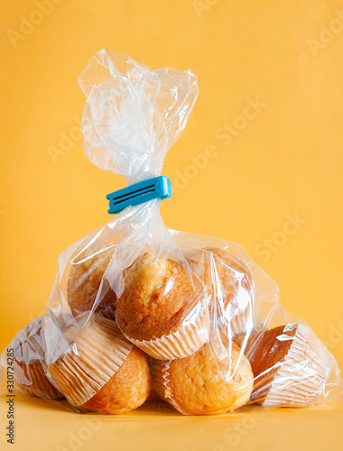 HOME CUPCAKES IN PLASTIC BAG ON YELLOW BACKGROUND