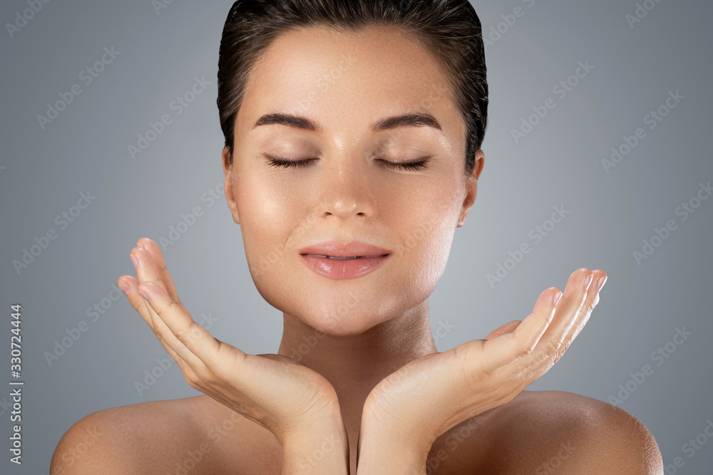 Young beautiful woman with perfect skin on gray background Young beautiful woman with perfect skin on gray background