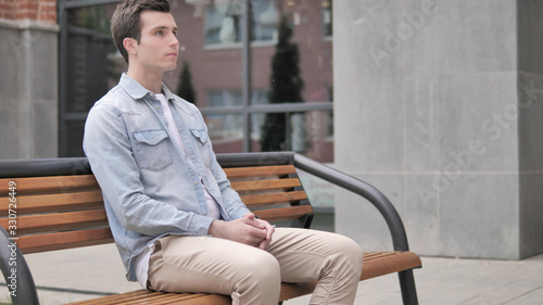 Serious Casual Young Man Sitting Outdoor