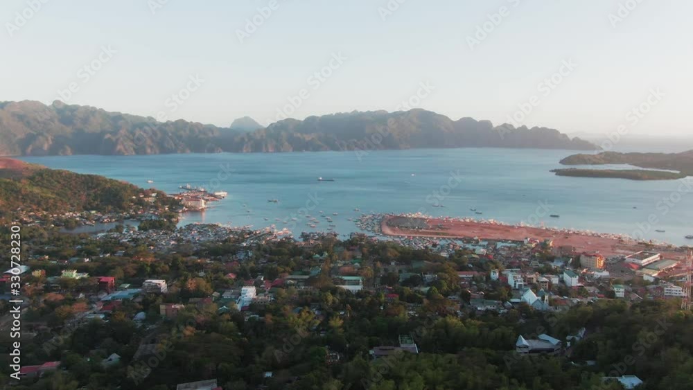 Aerial Landscape shot of a suburb of Coron City with the famous Coron Island in the background while sunset Aerial Landscape shot of a suburb of Coron City with the famous Coron Island in the background while sunset