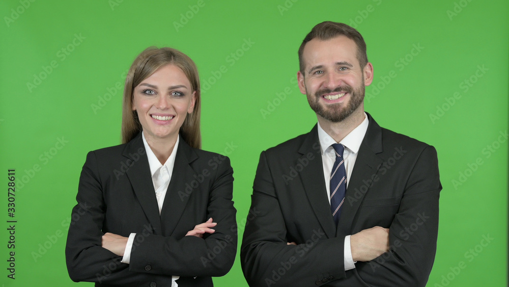 The Young Professional Male and Female Standing with Arms Crossed against Chroma Key The Young Professional Male and Female Standing with Arms Crossed against Chroma Key