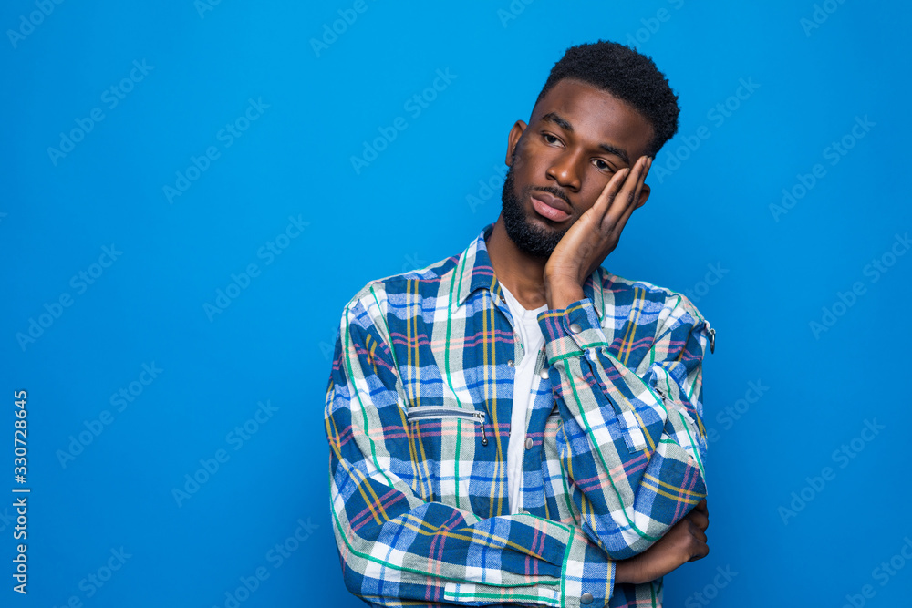 Young handsome african american man suffering from headache desperate and stressed because pain and migraine isolated on blue background