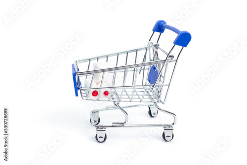 shopping cart with rolls of toilet paper on a white background. isolate © Duha