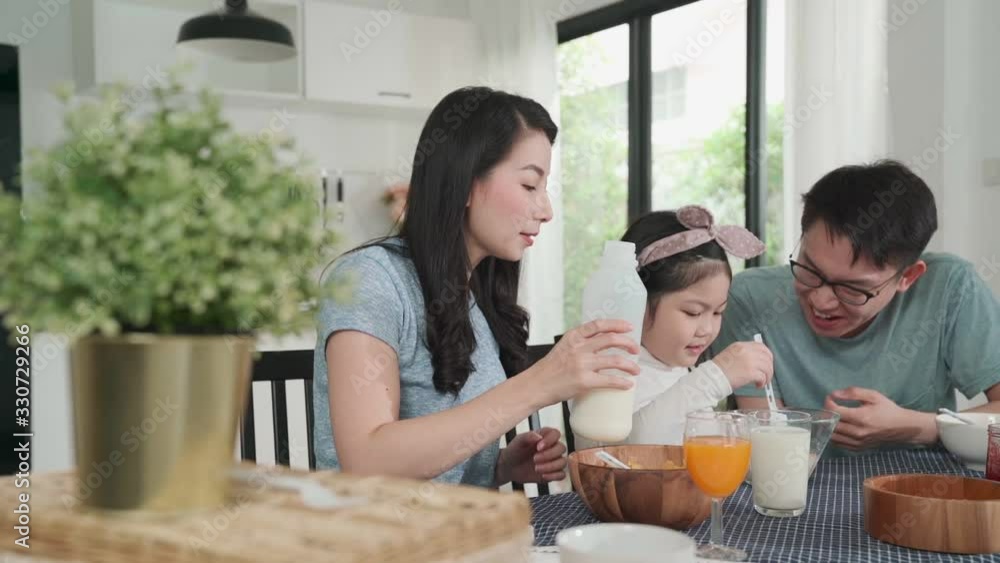 Happiness Asian Japanese family breakfast at home. young parent and daughter eat cereal drink orange juice on table in the kitchen morning daylight.quality moment bonding family ideas concept Happiness Asian Japanese family breakfast at home. young parent and daughter eat cereal drink orange juice on table in the kitchen morning daylight.quality moment bonding family ideas concept