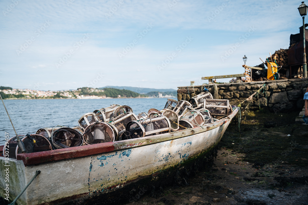 Fishing boat on ground because of low tide in Galicia, Northern Spain on a sunny day