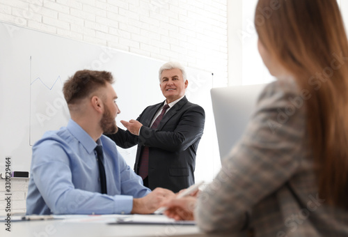 Wallpaper Mural Senior business trainer working with people in office Torontodigital.ca