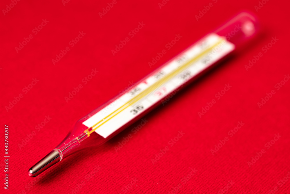 Fototapeta premium mercury thermometer on red background