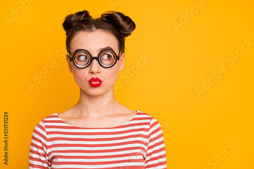 Closeup photo of pretty lady student send air kiss strange facial expression look side empty space wear circle freak specs striped red white shirt isolated bright yellow color background