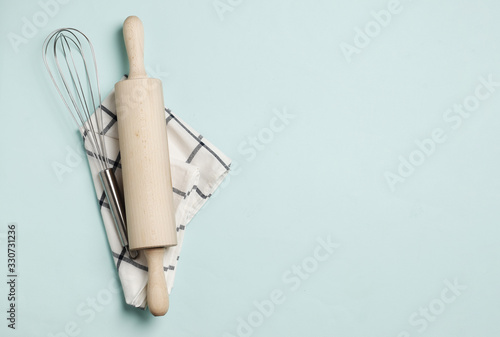 Rolling pin  whisk and dishcloth on a blue background.
