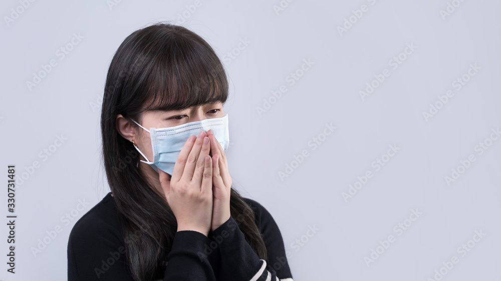 Woman coughing with face mask - young Asian covering the mouth by hand, feeling unwell illness isolated on white background, close up, copy space Woman coughing with face mask - young Asian covering the mouth by hand, feeling unwell illness isolated on white background, close up, copy space