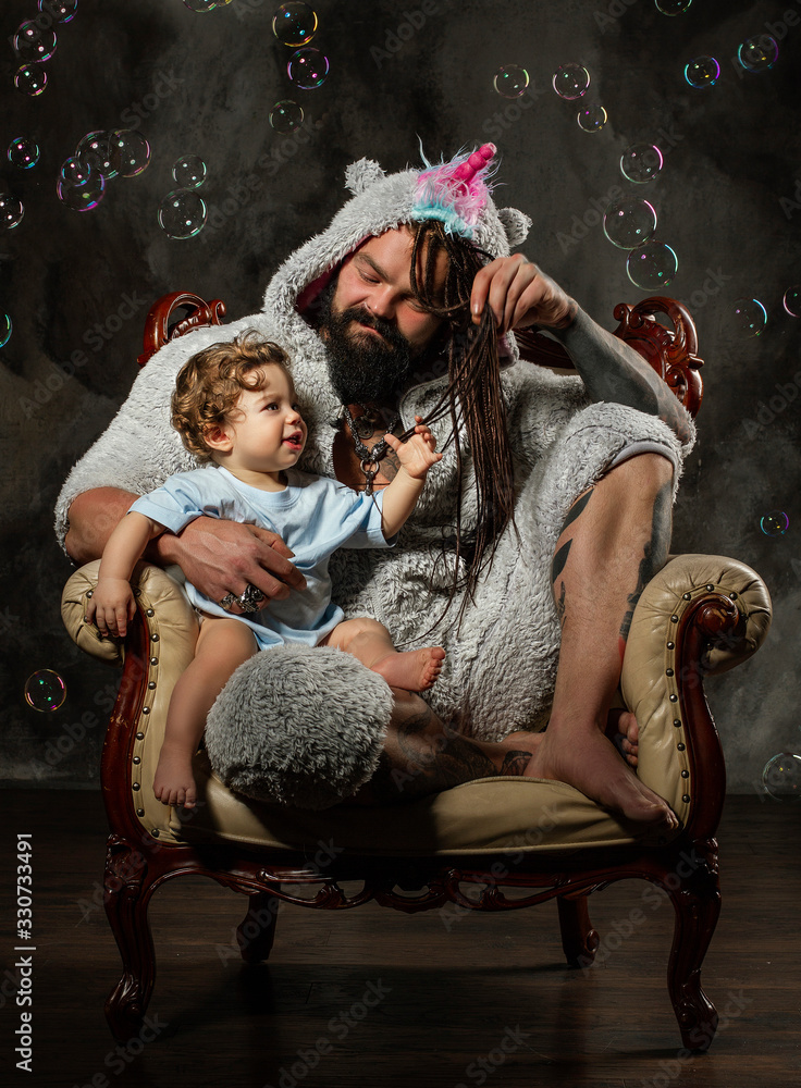dad in unicorn costume plays with happy baby