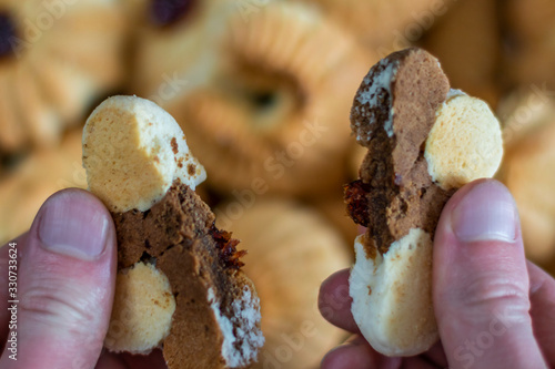 Breaking cookies into two halves on a blurry cookie background