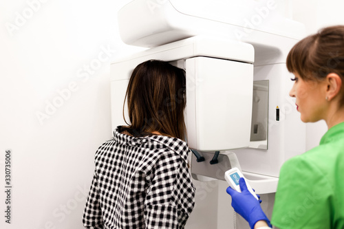 Dentist doctor does the patient a panoramic x-ray of the oral cavity. Procedure of orthopantomography
