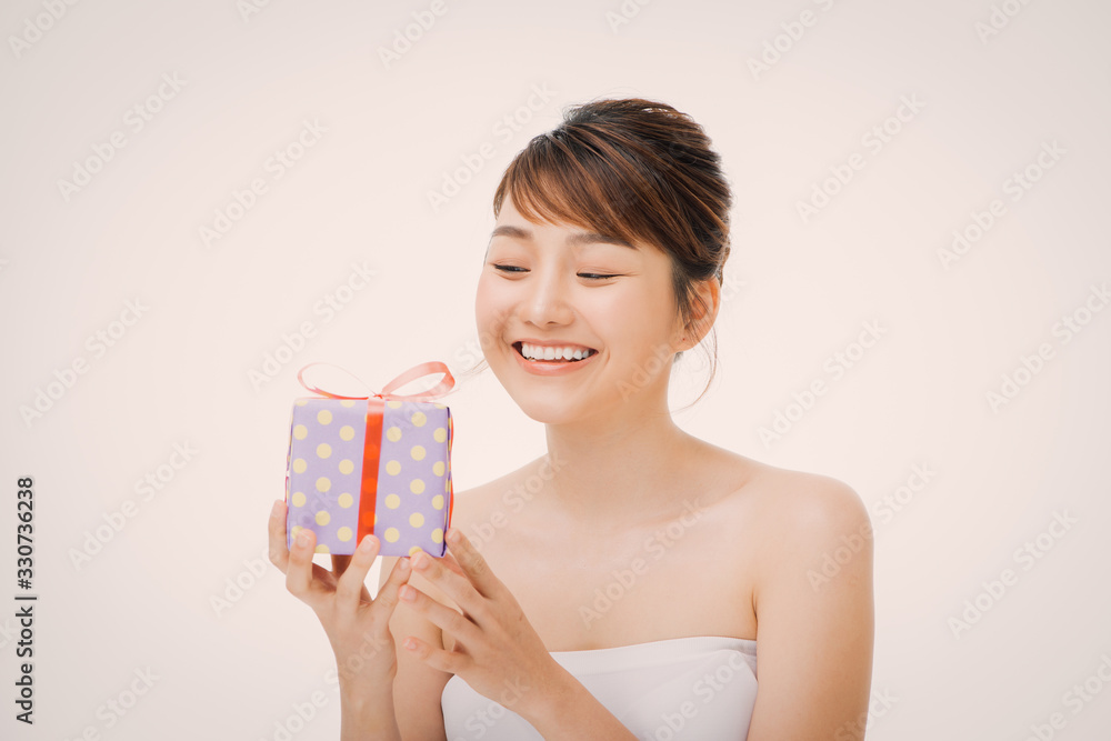 A portrait of beautiful girl holding a gift box isolated on white background A portrait of beautiful girl holding a gift box isolated on white background