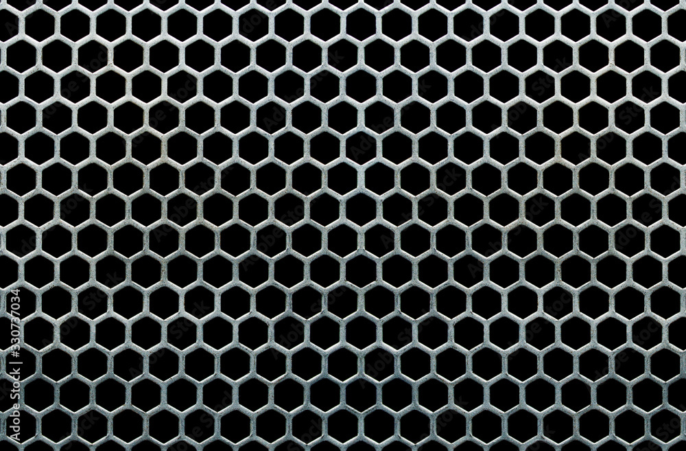 Metal grid with hexagonal cells on a black background Metal grid with hexagonal cells on a black background
