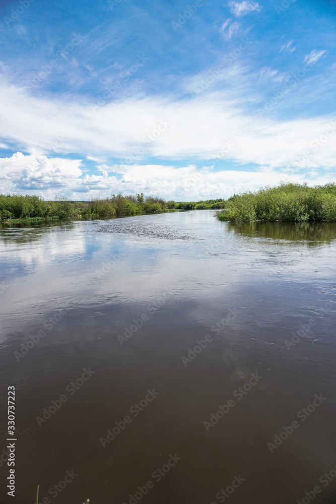 Beautiful spring river in the flowing nature. Colorful landscape in the morning and evening. Travel to deserted places of the world. Stock photo for design