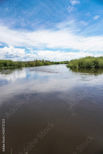 Fototapeta Naklejka Na Ścianę i Meble -  Beautiful spring river in the flowing nature. Colorful landscape in the morning and evening. Travel to deserted places of the world. Stock photo for design