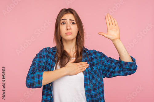 Tableau sur toile I swear, it's true! Portrait of girl in checkered shirt trying to look honest with funny grimace, keeping hand on chest and giving promise to tell truth
