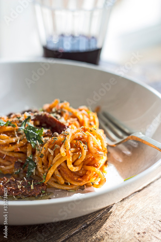 Espaguetis con tomate y un vaso de vino