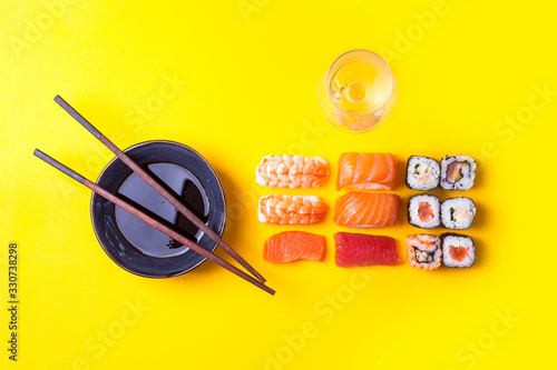Varias porciones de Sushi ordenadas con salsa de soja y vino blanco