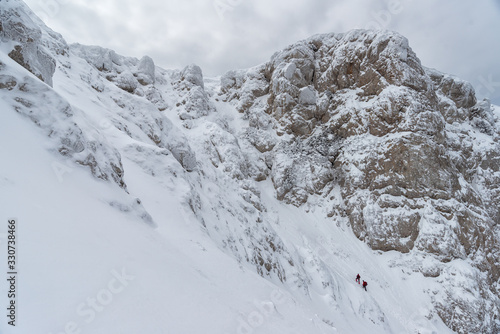 Wallpaper Mural Two climbers under the steep winter slope of a mountain plateau in Crimea Torontodigital.ca