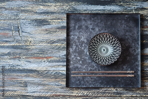 Vászonkép A bowl & chopsticks on a tea salver on a multi-colored surface