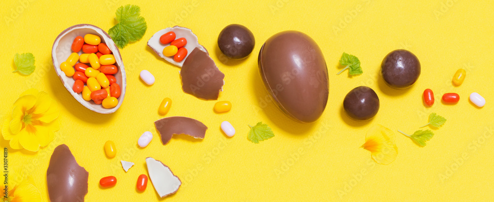 Easter yellow background with chocolatte eggs, candy and spri Easter yellow background with chocolatte eggs, candy and spri